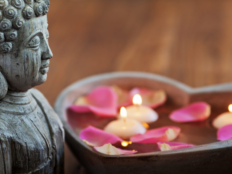 Buddha mit Lotusblüten und Kerzen